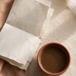 A folded church bulletin beside an untouched cup of coffee, representing the tension between faithful service and genuine rest.