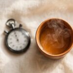 A stopped stopwatch beside a slowly steaming cup of tea, representing an identity no longer measured entirely by speed.