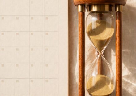 An hourglass beside a calendar page for the current month, representing full attention given to the present season rather than the next one.
