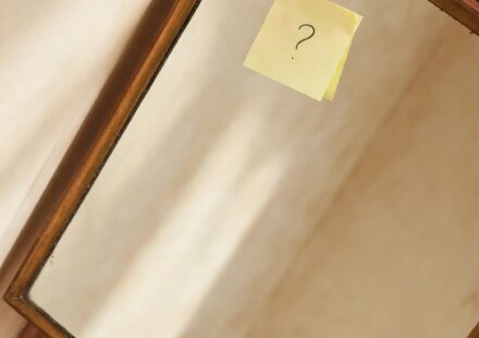 A small sticky note on a mirror corner, representing a pause taken before saying yes to a new commitment.