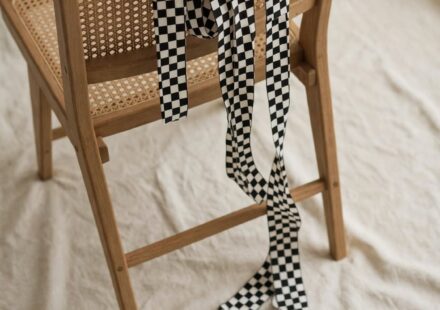 A ribbon draped over an empty chair, representing the quiet emptiness that can follow a long-chased achievement.