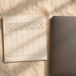A weekly calendar page crossed off beside a closed laptop, representing a week finally released rather than replayed.